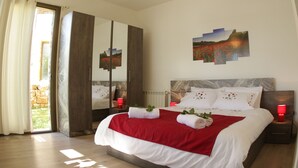 A bedroom with a large bed, a wardrobe, a mirror, and a painting on the wall. - Heavenly Duplex with 2 gardens at Redrock Faqra (faqra)