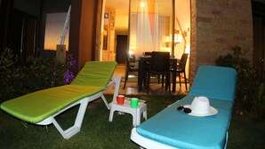A patio area with two lounge chairs, a small table, and a chair. - Heavenly Duplex with 2 gardens at Redrock Faqra (faqra)