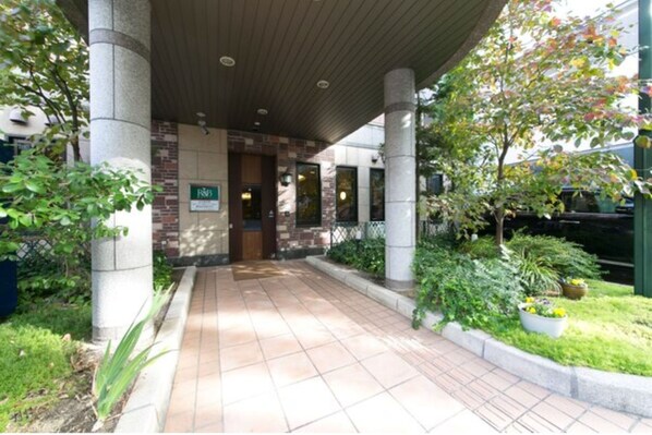 Stroll through the beautifully landscaped entrance, marked by a sign and flanked by stone columns.