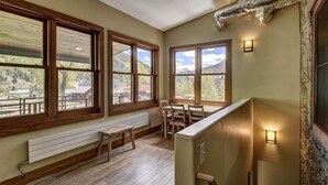 A room with large windows, a wooden bench, a table, and a staircase. - Modern Downtown Loft in Heart of Silverton (Silverton)