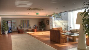 A spacious lobby with a large seating area, a reception desk, and a staircase leading to upper floors. - Vilanova Villas (Albufeira)