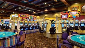 A casino with multiple slot machines and blackjack tables.