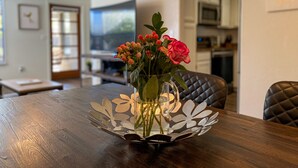 A dining table with a vase of flowers and a decorative metal tray. - AFFLUENCE ABOUNDS ~ FOOTHILLS CONDO ~ SLEEPS 6 (Tucson)