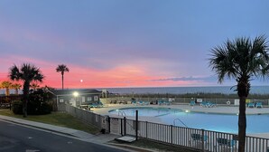 Ein Pool mit Liegestühlen und Blick auf den Sonnenuntergang.