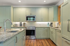 A kitchen with a stainless steel range, a microwave, and a built-in oven. - Outpost: Moose Creek 16 - Private Hot Tub! (Teton Village)