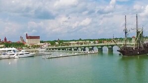 A bridge over a calm body of water with a large ship docked nearby. - Ocean View Unit 3305 - Ocean & Racquet Resort [20% DISCOUNT ON 7+ NIGHT STAYS] (St. Augustine Beach)
