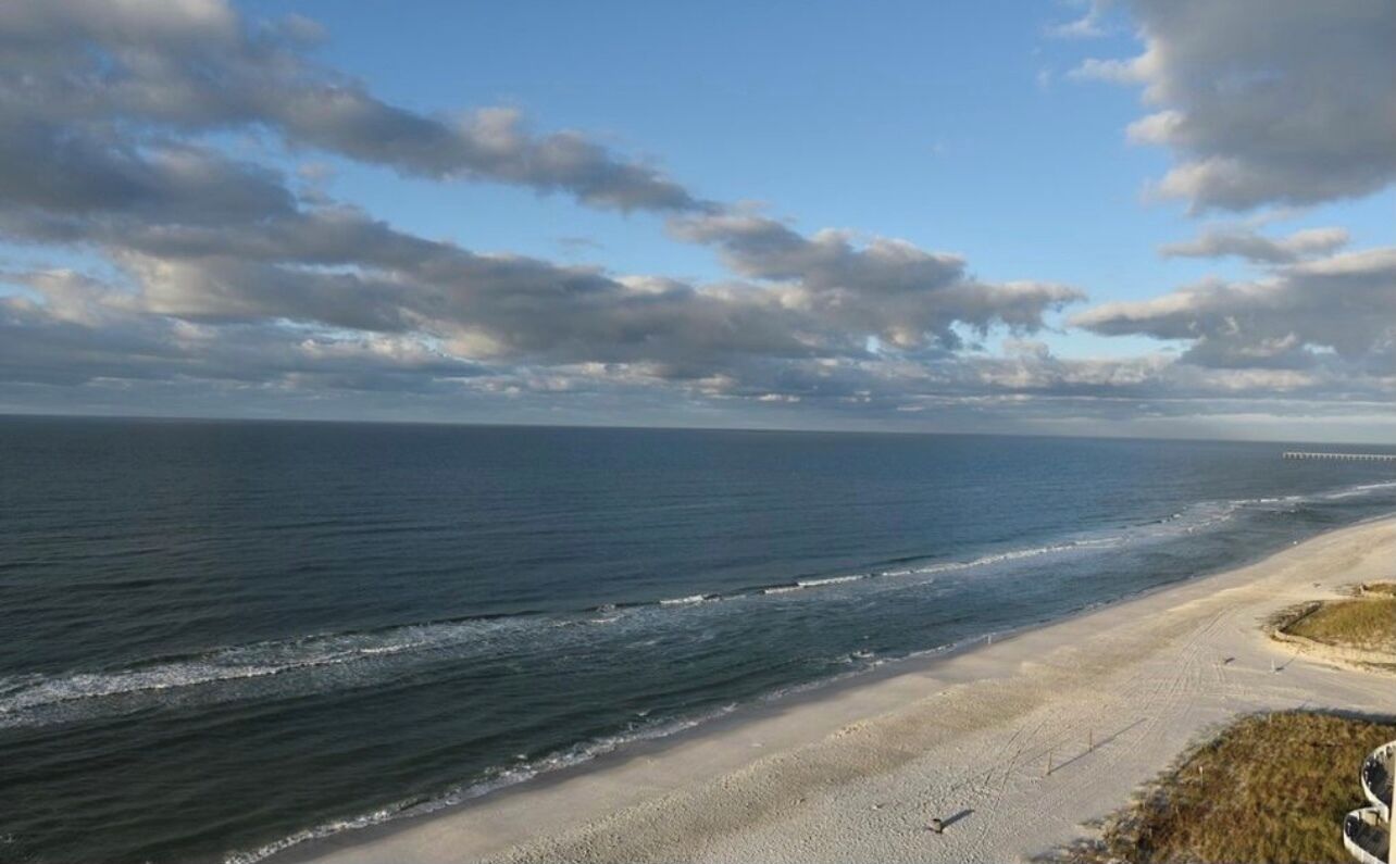 Una playa con cielo despejado y océano.