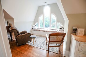 A cozy reading nook with a cushioned bench, two chairs, and a small table. - Entire Home l Chick Inn on Main (Summerville)