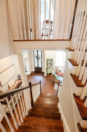 A wooden staircase with white balusters leading to a landing. - Entire Home l Chick Inn on Main (Summerville)