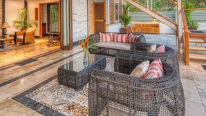 A modern interior with a bamboo ceiling, wicker furniture, and a glass coffee table. - Simply Spectacular Luxury Ocean View Villa!  (Uvita)