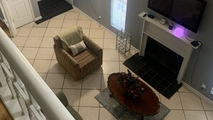 Ein Wohnzimmer mit Kamin, Fernseher und einer Couch.