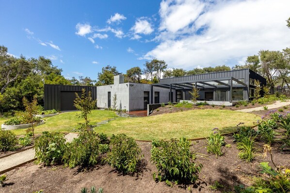 A modern house with a flat roof, large windows, and a garden with various plants. - CONTEMPORARY, MODERN, SPACIOUS & STYLISH ROSETTA, SORRENTO (Sorrento)
