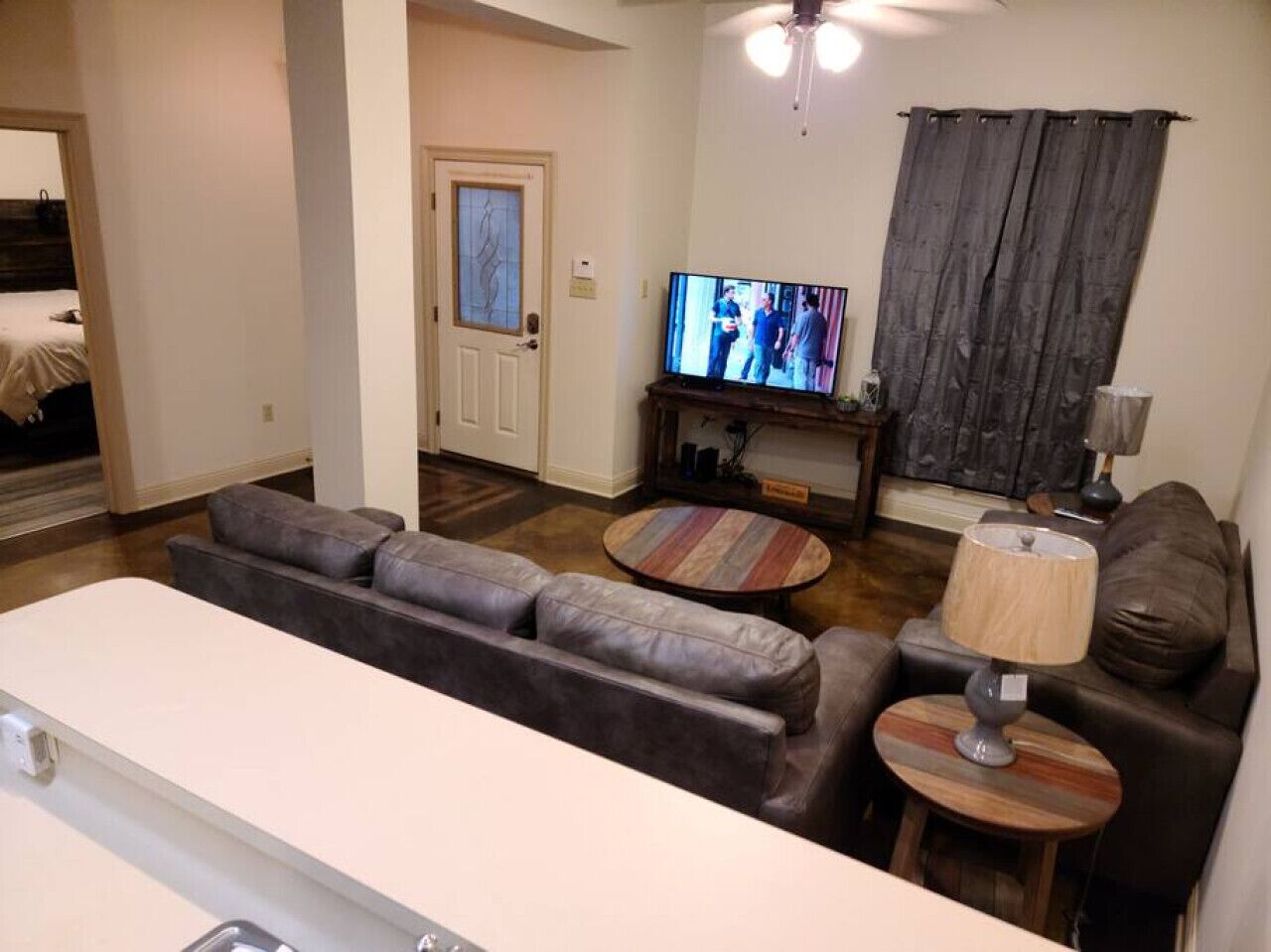 A modern living room with a sofa set, a coffee table, a TV, and a lamp.