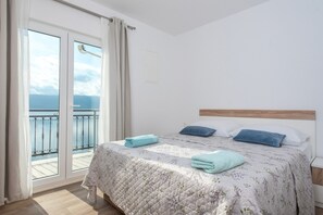 Una camera da letto con un letto, vista mare e un balcone.