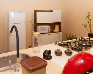 Habitación cuádruple familiar | Cocina privada | Frigorífico, microondas, placa de cocina y utensilios de cocina