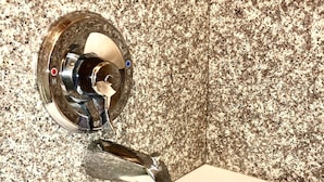 Un lavabo de salle de bain avec un robinet chromé et un pare-éclaboussures en granit.