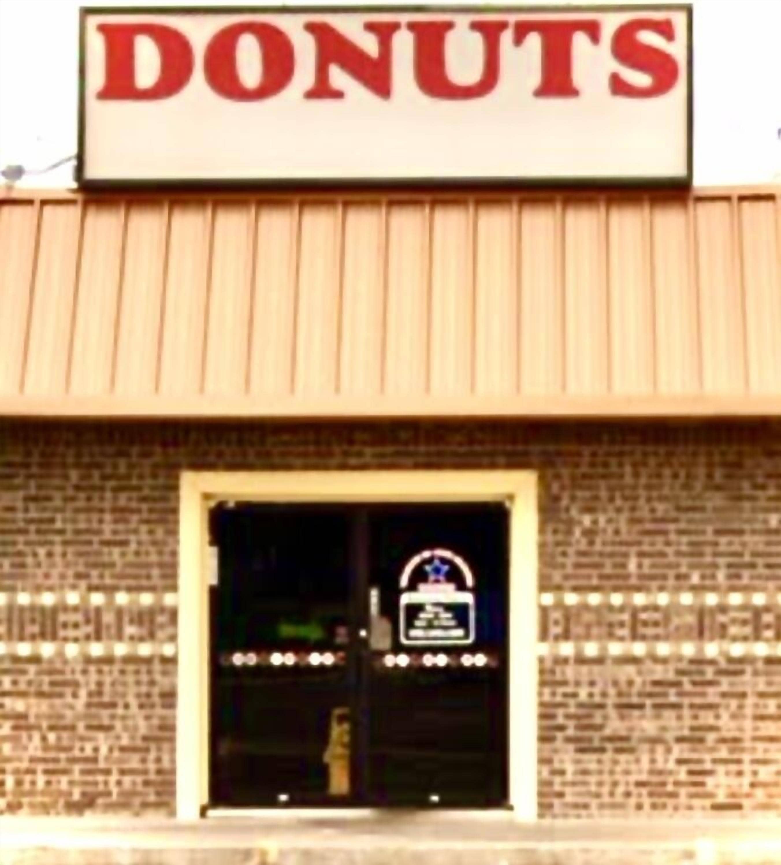 A building with a sign that reads "DONUTS" above the entrance.