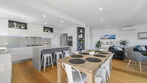 A modern kitchen with white cabinetry, a central island, and bar stools.
