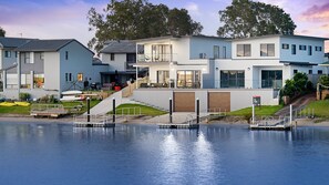 A waterfront property with modern houses, a dock, and a 'For Sale' sign. - Reflections on the water 2B River Park Road, Port Macquarie (PORT MACQUARIE)