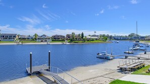 A marina with boats docked, a sandy beach, and residential buildings in the background.