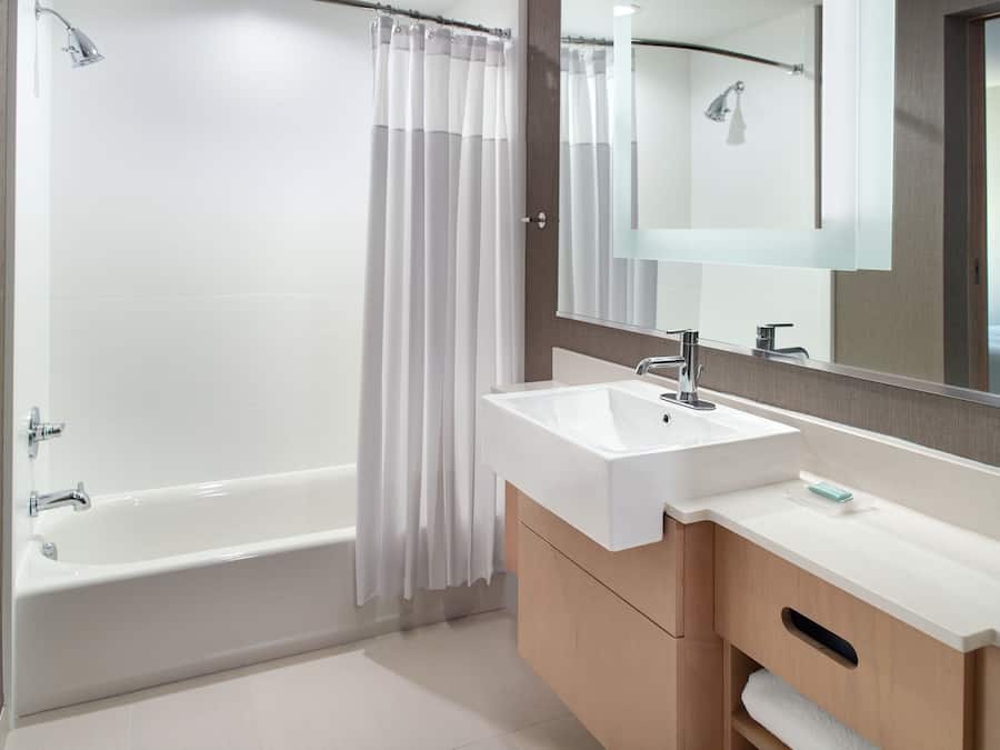 A modern bathroom with a bathtub, a sink, and a mirror.