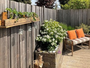 A wooden fence with a planter box containing white flowers and a decorative animal figure. - 2 bedroom accommodation in Edzell, near Brechin (Edzell, near Brechin)