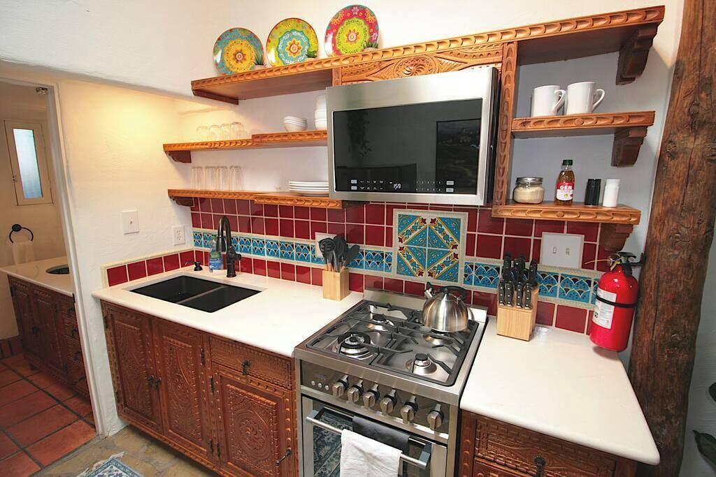 A kitchen with a stove, microwave, and wooden cabinets.