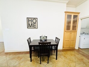 A dining area with a table and chairs, a cabinet, and a washing machine.