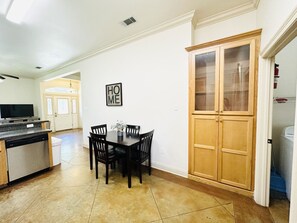 A kitchen with a dining table, chairs, a wooden cabinet, and a 'HOME' sign on the wall. - Villa 3, spacious townhouse in Tickfaw, LA (Tickfaw)