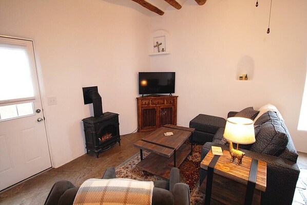 A cozy living room with a fireplace, a television, a sofa, and a coffee table.