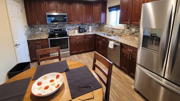 A modern kitchen with wooden cabinets, stainless steel appliances, and a tiled backsplash. - Great location, 10 min downtown Denver. 15 to Red Rocks. Regis university 5 min  (Mountain View)