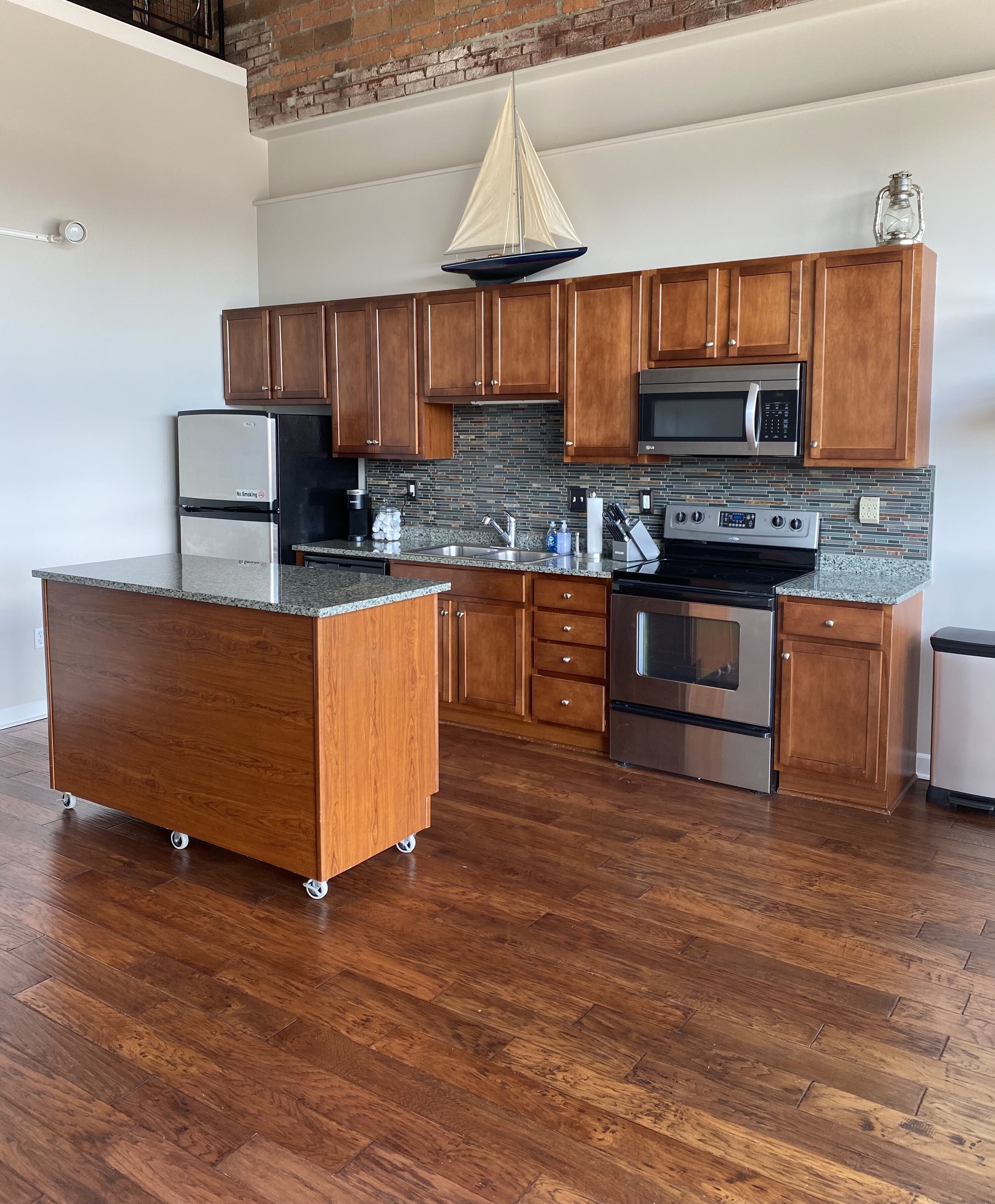 A modern kitchen with wooden cabinets, stainless steel appliances, and a floating island.