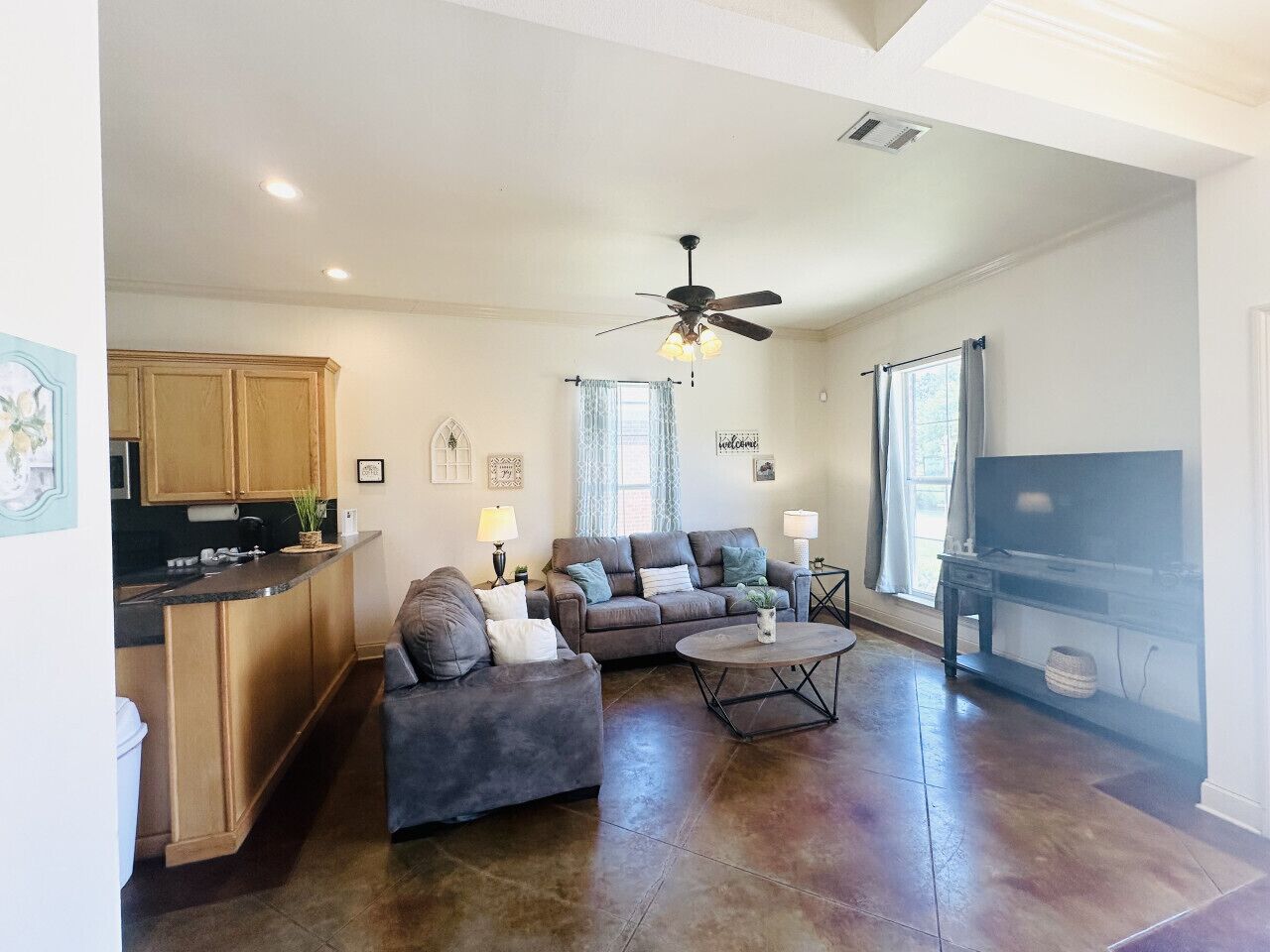 A spacious living room with a sofa set, a coffee table, and a television.