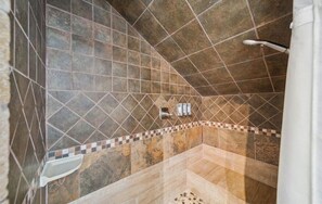 Eine Dusche mit gefliesten Wänden und einem Eckwaschbecken.