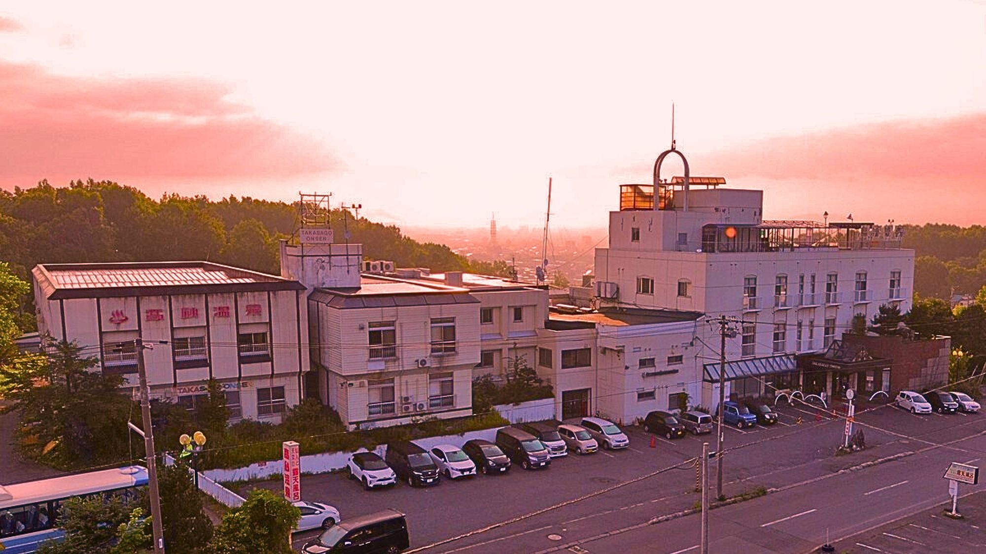 A multi-story building with a parking lot in front.