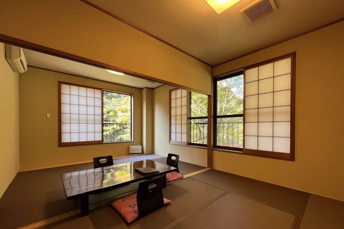 Une pièce de style japonais traditionnel, avec un sol recouvert de tatamis, une table basse et des portes coulissantes.