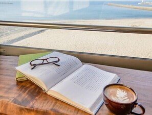 A window view of a beach with a table inside a room. - Ocean Front Hamada-kan (Hitachinaka)