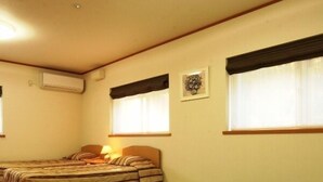 Una habitación con dos camas, una mesita pequeña y un tapete verde.