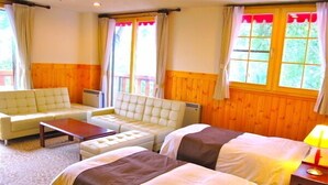 A room with two beds, a sofa, and a table. - Hotel Andermatt (Nagawa)