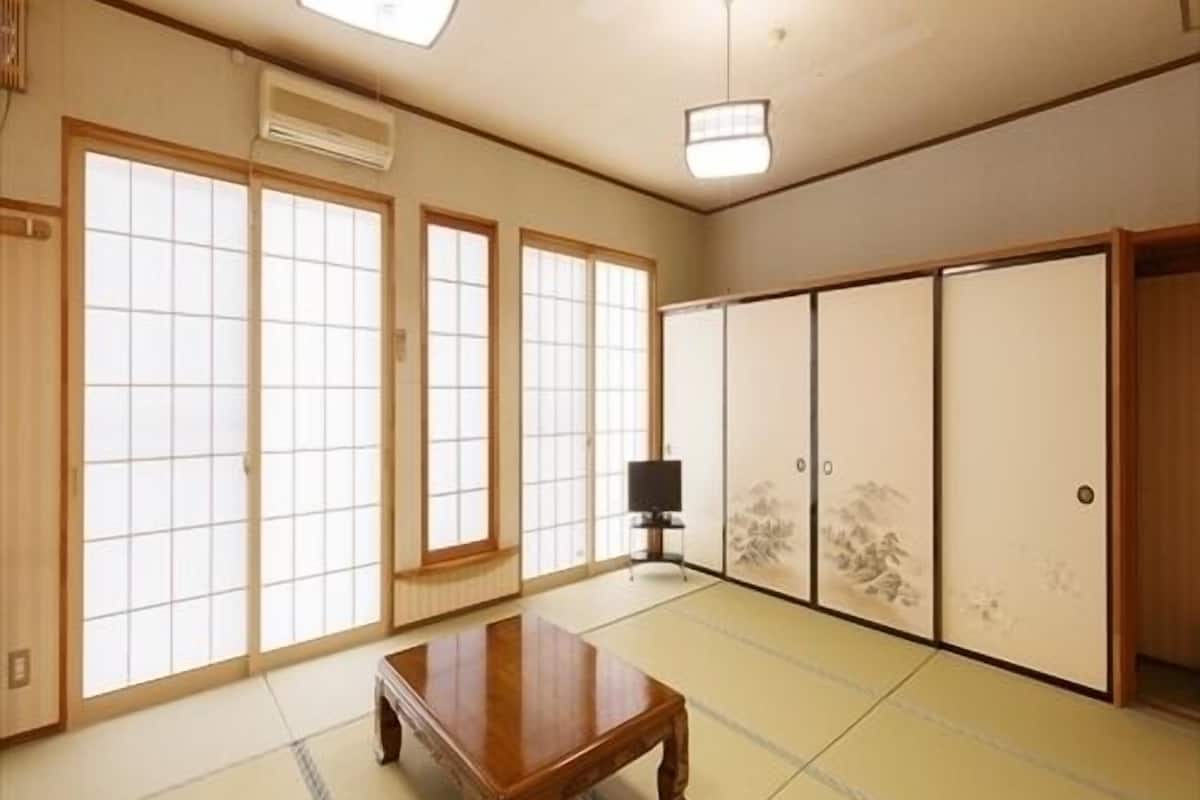 Perinteinen japanilainen huone, jossa on tatamimatto, liukuseinät, televisio ja kattotuulettimet.