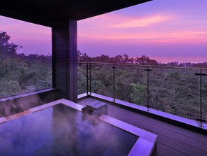 A hot tub on a balcony with a view of trees and a sunset. - Izu Kogen Onsen Lucy Kiki (Ito)