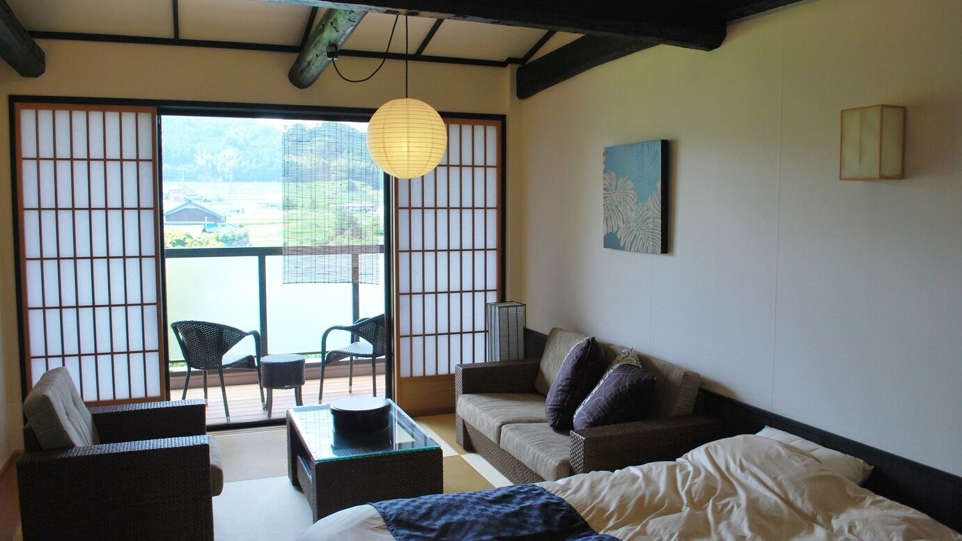 Une pièce de style japonais traditionnel, avec un sol recouvert de tatamis, une table basse, un canapé et un lit.