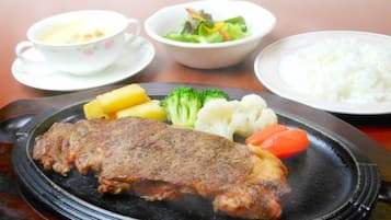 A plate with a steak, vegetables, and rice.
