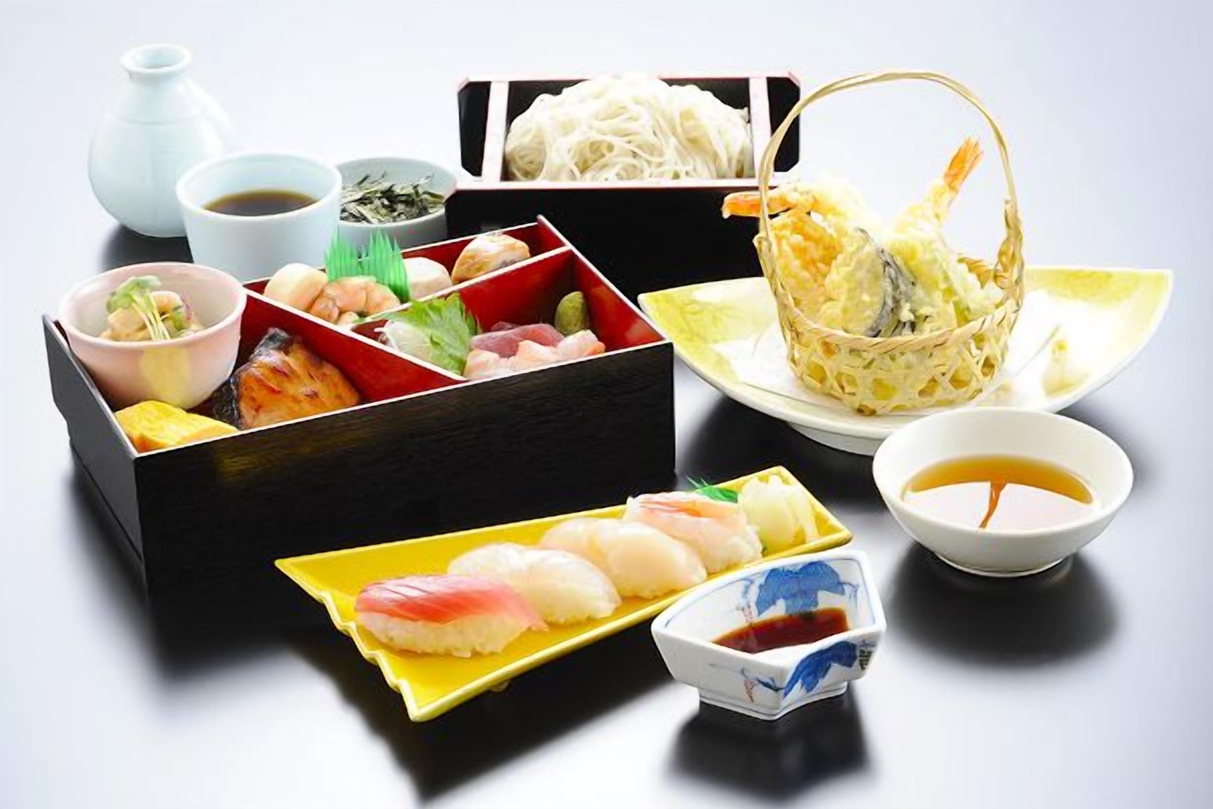 A variety of sushi dishes and condiments arranged on a table.