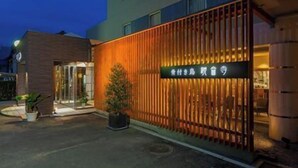 En hotellentrén med en träfasad och en skylt på ett främmande språk.