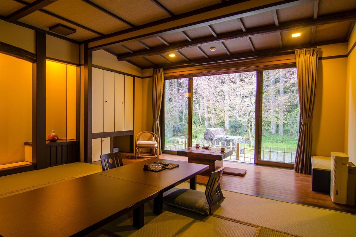 Una tradizionale stanza in stile giapponese con pavimento in tatami, un tavolino e porte scorrevoli.