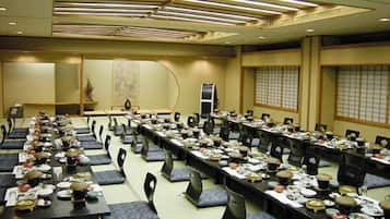 A conference room with long tables, chairs, and presentation screens.