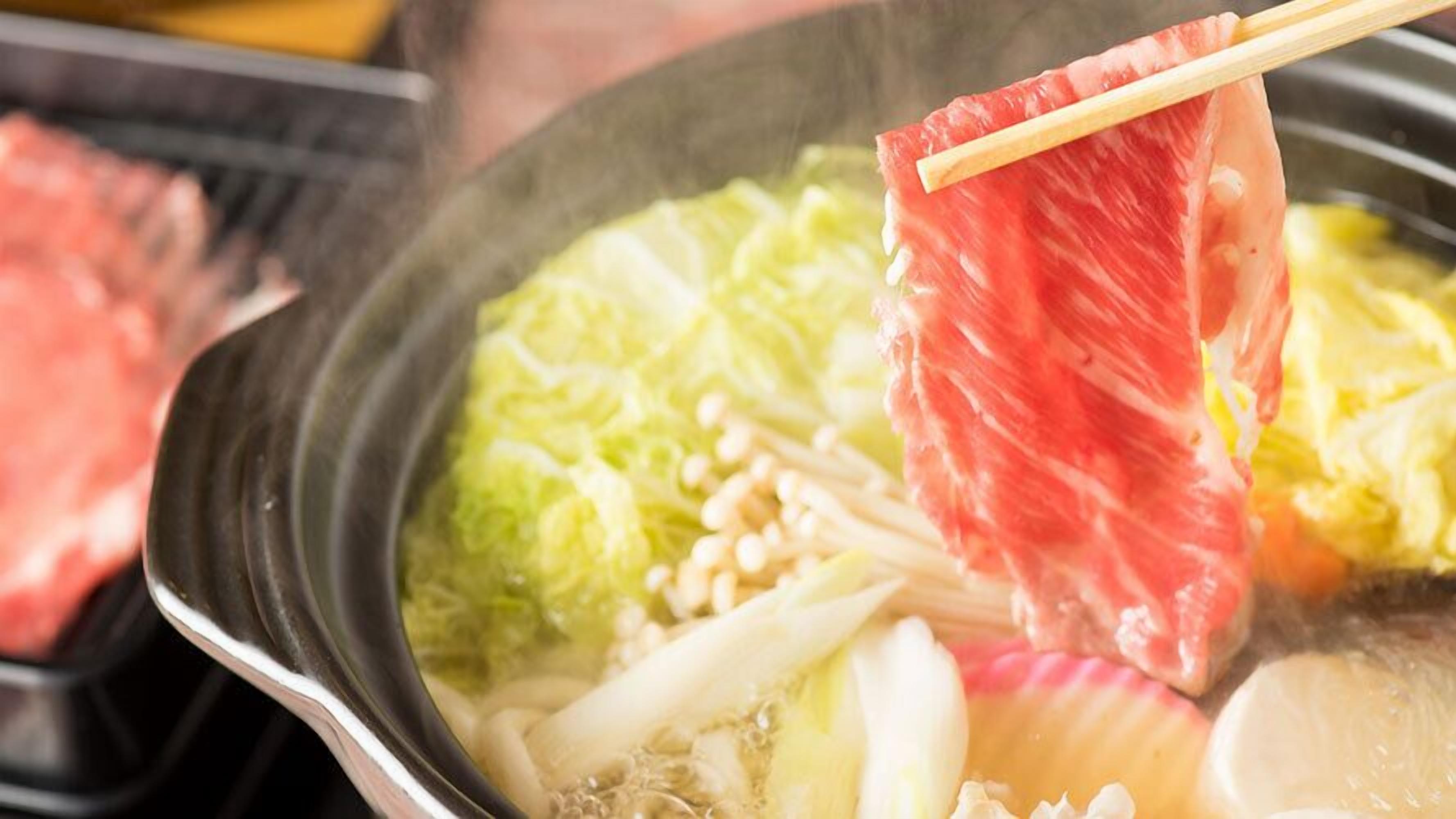 Une fondue chinoise avec de la viande et des légumes.