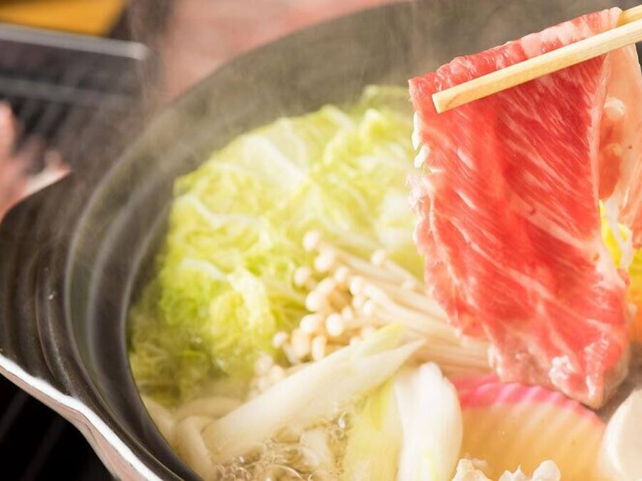 Une fondue chinoise avec de la viande et des légumes.