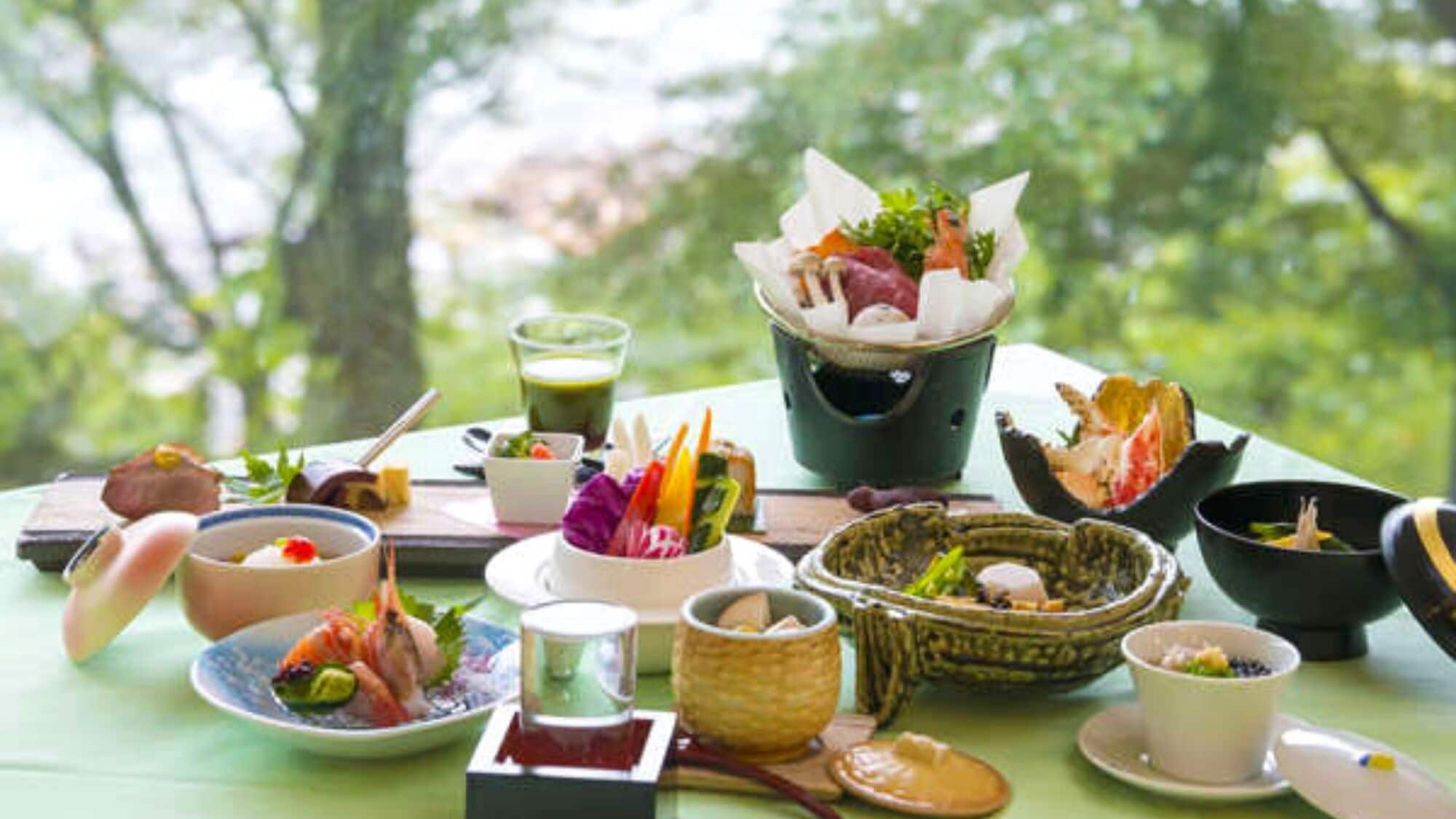 A table with various dishes and drinks, likely a meal setting outdoors.